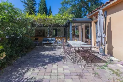 a patio with a table and chairs and an umbrella at Villa sur Domaine Aix - Piscine & Tennis - Wagner in Aix-en-Provence