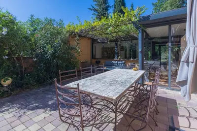 a wooden table and chairs on a patio at Villa sur Domaine Aix - Piscine & Tennis - Wagner in Aix-en-Provence