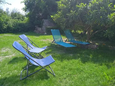 three chairs sitting in the grass in a yard at Tiny House T1 in Entraigues-sur-la-Sorgue