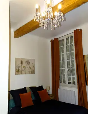 a chandelier in a room with a bed and a window at AQUA TERRA-Studio Cozy-Aix Historic Center- SMART TV-WIFI in Aix-en-Provence
