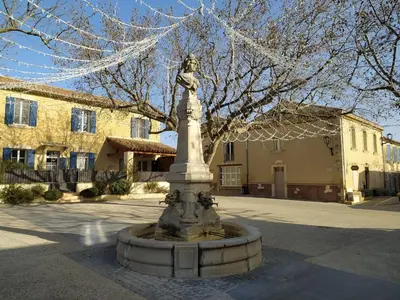 a statue of a woman sitting on top of a fountain at Niché au cœur de la Provence - VERNEGUES in Vernègues