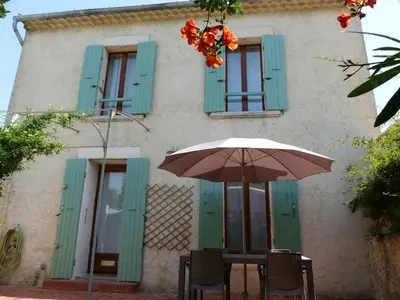 a table with an umbrella in front of a building at Niché au cœur de la Provence - VERNEGUES in Vernègues