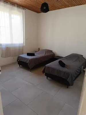 a room with two beds and a window at La Villa des Trois in Cavaillon