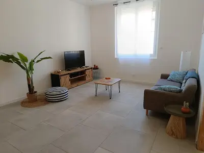 a living room with a couch and a tv at La Villa des Trois in Cavaillon