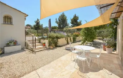 a patio with a table and chairs in a yard at 4 Bedroom Cozy Home In Eygalières in Eygalières