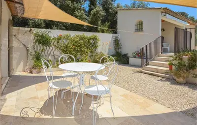 a white table and chairs in a yard at 4 Bedroom Cozy Home In Eygalières in Eygalières