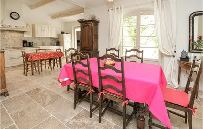 a kitchen and dining room with a pink table and chairs at 4 Bedroom Cozy Home In Eygalières in Eygalières