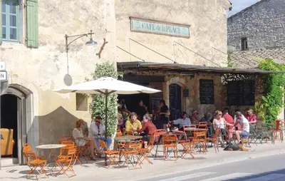 a group of people sitting at a restaurant with an umbrella at 4 Bedroom Cozy Home In Eygalières in Eygalières