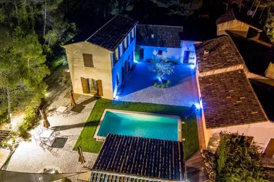 an aerial view of a house with a swimming pool at night at Domaine la Garenne in Saint-Marc-Jaumegarde