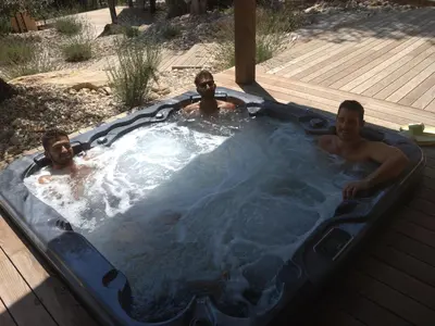 three men in a jacuzzi in a backyard at Domaine la Garenne in Saint-Marc-Jaumegarde