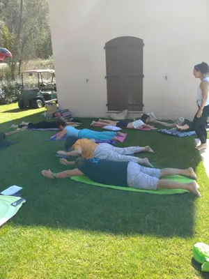 a group of people laying in the grass doing yoga at Domaine la Garenne in Saint-Marc-Jaumegarde