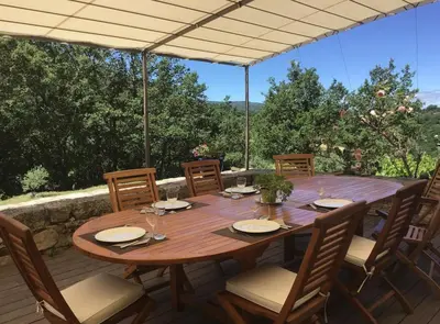 a wooden table and chairs on a patio at Domaine de Battarel, 4 hectares en Luberon in Saint-Martin-de-Castillon