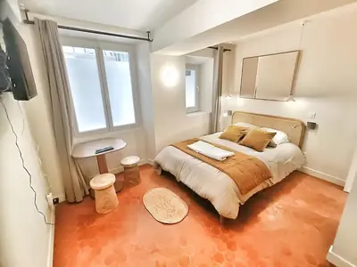 a large bed in a room with two windows at Le Mignet by Rentalaix in Aix-en-Provence