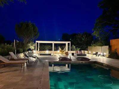 a swimming pool in a backyard at night at Villa Soleil Piscine Jacuzzi Pétanque Espace bbq billard et salons extérieurs in Aix-en-Provence