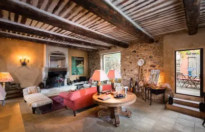 a living room with a red couch and a table at Maison Vignes in Roussillon