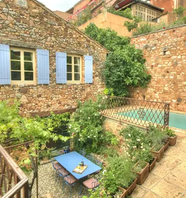 a blue table in front of a brick building at Maison Vignes in Roussillon