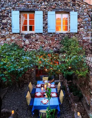 a blue table and chairs in front of a building at Maison Vignes in Roussillon