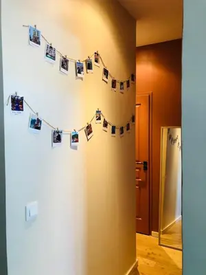 a hallway with a string of photos on a wall at Chez Anna - Centre-ville - in LʼIsle-sur-la-Sorgue
