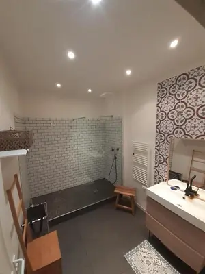 a bathroom with a bench and a sink and a mirror at Chez Anna - Centre-ville - in LʼIsle-sur-la-Sorgue