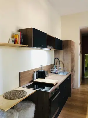 a kitchen with black cabinets and a counter top at Chez Anna - Centre-ville - in LʼIsle-sur-la-Sorgue