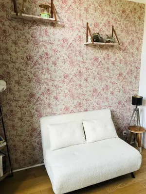 a white couch in a room with pink wallpaper at Chez Anna - Centre-ville - in LʼIsle-sur-la-Sorgue