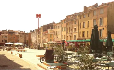 a city street with tables and chairs and umbrellas at Le petit cardeur in Aix-en-Provence