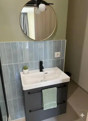 a bathroom with a white sink and a mirror at Le petit cardeur in Aix-en-Provence