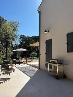 a patio with a table and chairs next to a building at Villa Mimosa in Venasque