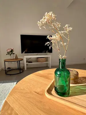 a green vase with flowers sitting on a table at Villa Mimosa in Venasque