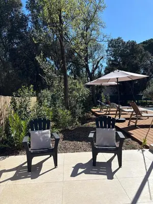 two chairs and an umbrella on a patio at Villa Mimosa in Venasque
