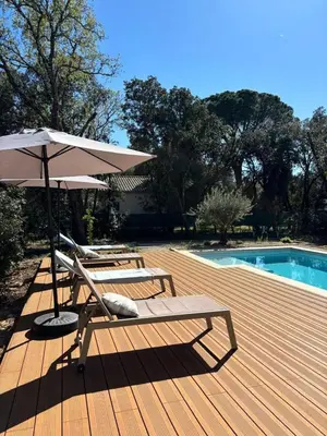 two lounge chairs and an umbrella next to a pool at Villa Mimosa in Venasque