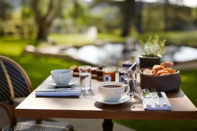 a wooden table with coffee and a bowl of bread at Domaine de Fontenille - Fontenille Collection in Lauris
