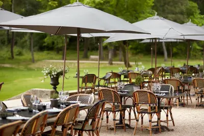 a group of tables and chairs with umbrellas at Domaine de Fontenille - Fontenille Collection in Lauris