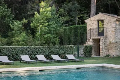 a group of lounge chairs next to a swimming pool at Domaine de Fontenille - Fontenille Collection in Lauris