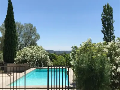 a swimming pool in a garden with trees at Le cabanon in Vaugines