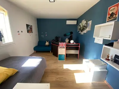 a room with a bed and a blue wall at Le bois des chênes in Peypin-dʼAigues