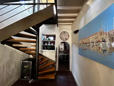 a staircase in a building with a clock on the wall at Maison robion in Robion en Luberon