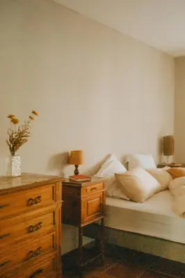 a bedroom with a bed with white pillows and a dresser at Maison Loucacia in Mormoiron