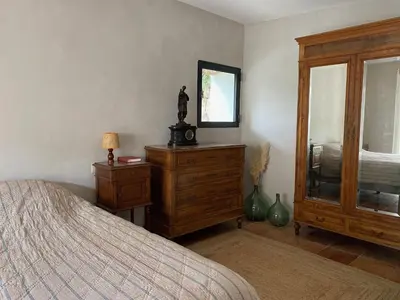 a bedroom with a bed and a dresser and a mirror at Maison Loucacia in Mormoiron