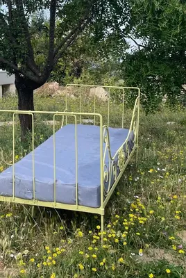 a bed sitting in a field of flowers at Bastidon, Petite bastide pour 2 avec bassin et jardin privé in Crillon-le-Brave
