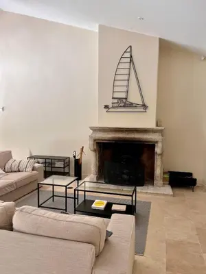 a living room with a fireplace with a sail on the wall at Magnifique Mas provencal au coeur des vignes in Mazan