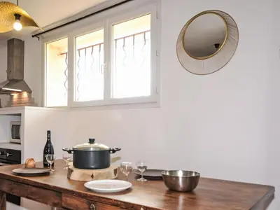 a kitchen with a table with a pot and a mirror at Apartment Les Santons by Interhome in Peypin-dʼAigues