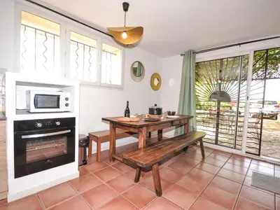 a kitchen with a table and a microwave at Apartment Les Santons by Interhome in Peypin-dʼAigues