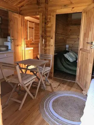 a room with a table and chairs in a log cabin at chalet le domaine des cigales in Cavaillon