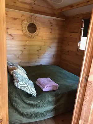 a small room with a bed in a log cabin at chalet le domaine des cigales in Cavaillon