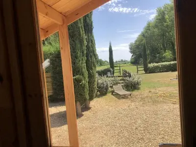 a view of a yard with a bench and trees at chalet le domaine des cigales in Cavaillon