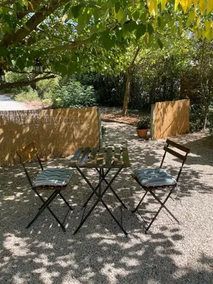 two folding chairs and a table and two chairs at Charmant Mazet en campagne provencale in Châteaurenard