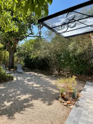 a patio with two chairs and a tree at Charmant Mazet en campagne provencale in Châteaurenard