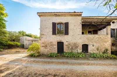 an old stone house with black shutters at Mas de Thésée Piscine & 12 ha privés in Reillanne