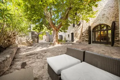 a couch sitting in the courtyard of a building at Mas de Thésée Piscine & 12 ha privés in Reillanne